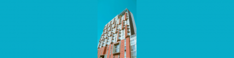 Low-angle shot of apartment building on light blue background
