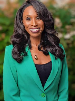 Person smiling with green jacket and black shirt